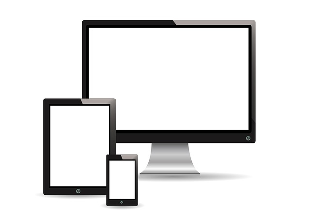 Smartphone vor einem Tablet und einem Desktopbildschirm