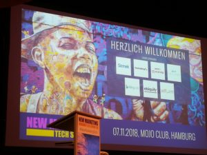 Foto der Leinwand und des Rednerpults auf der New Marteing Tech Summit 2018 im Mojo Club in Hamburg.