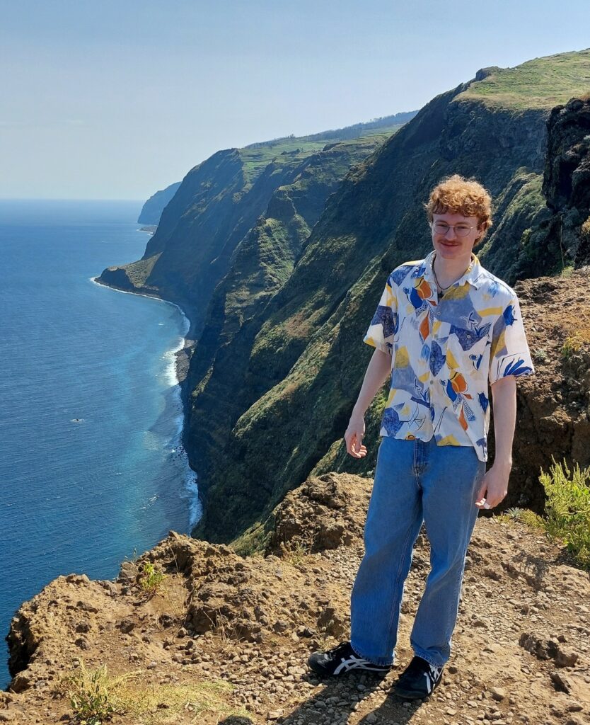 Junger Mann (Jan) an einer steilen Felsk&uuml;ste in Madeira mit Blick &uuml;ber den blauen Atlantik
